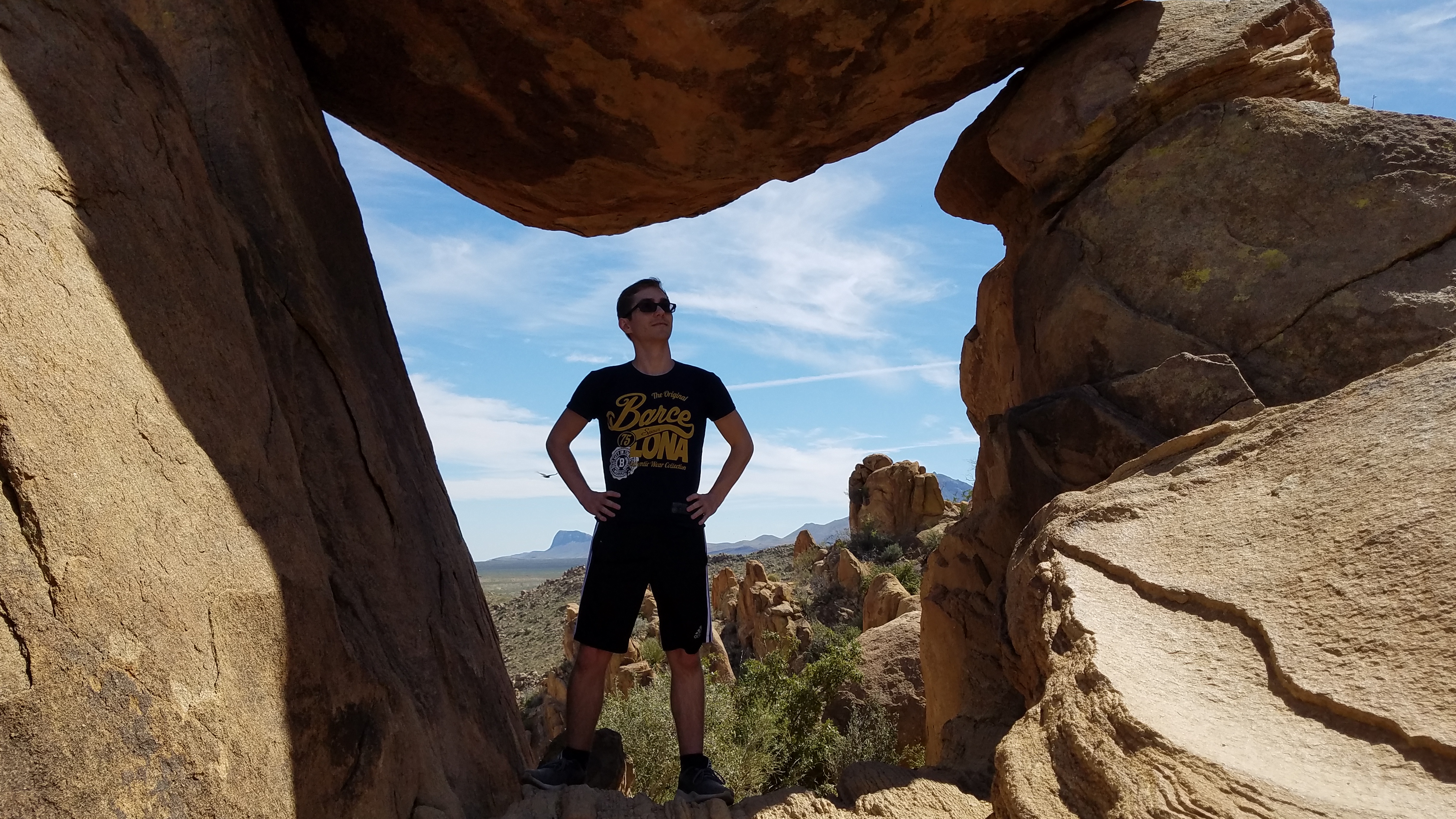 A picture of Dillon standing under a rock formation at Big Bend National Park.