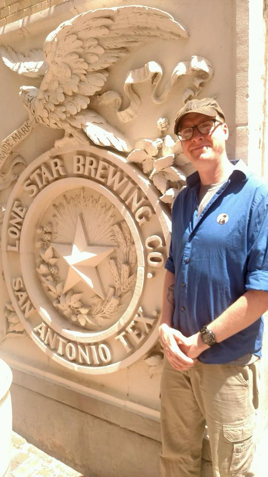 Gentry standing by Lonestar Brewing Crest